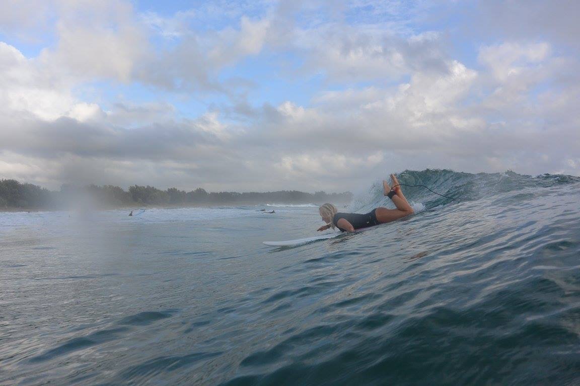 Flora Muijzer paddling out on her surfboard at dawn, a lifelong passion since qualifying as a surf instructor in Australia