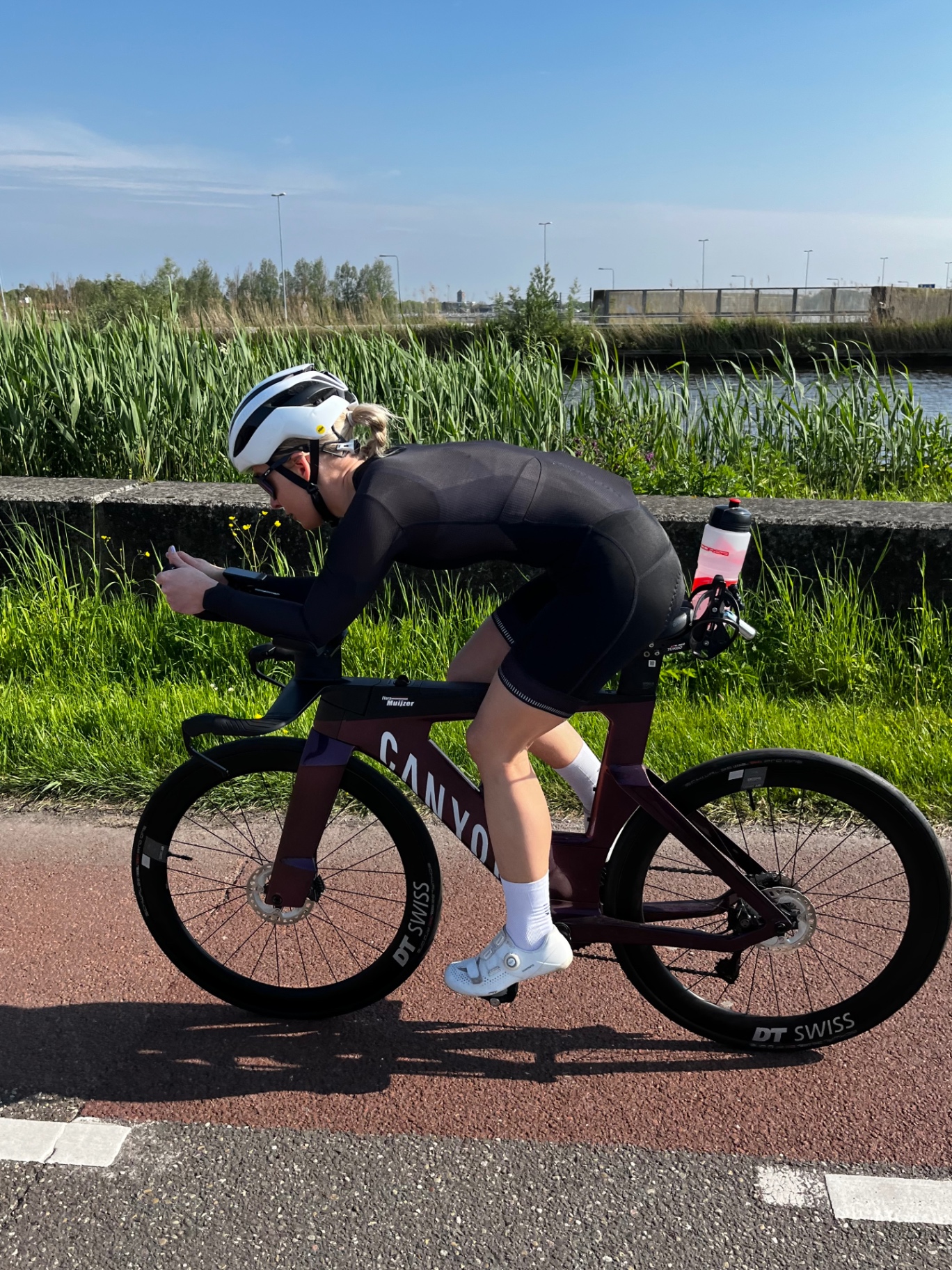 Before: triathlete training on a Canyon time-trial bike — starting position reviewed by Flora for injury-driving load patterns.