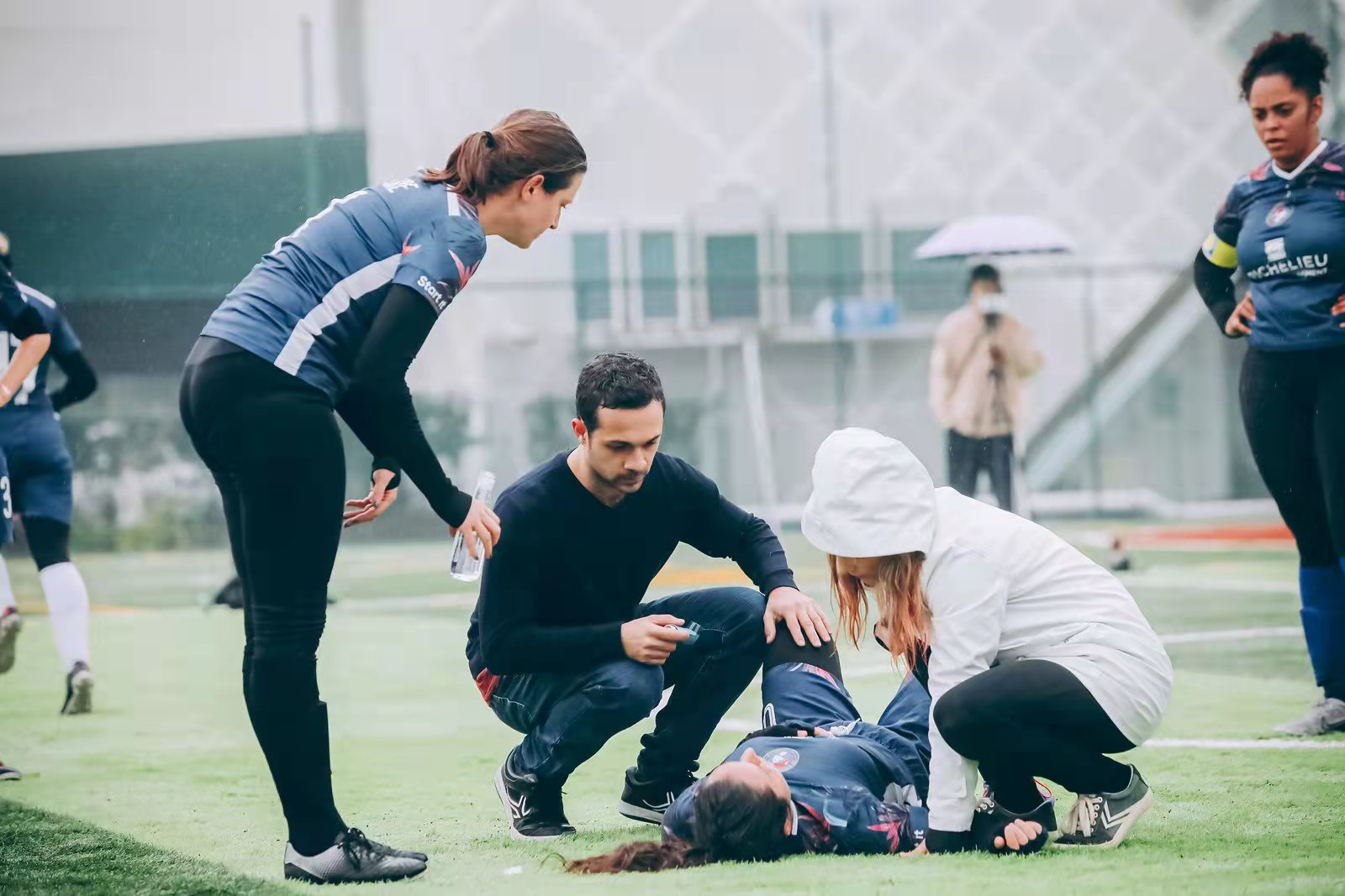 Flora on the football field helping an injured player for the Shanghai Women's Football League.