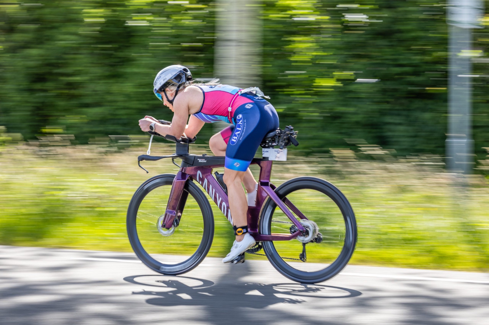 Triathlete in aerodynamic tuck on a Canyon time-trial bike at race speed — the kind of position Flora analyses to prevent injury and advise on aerodynamics.